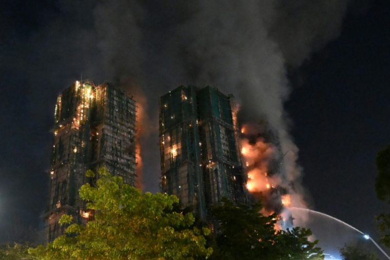 Des pompiers luttent contre un incendie qui s'est déclaré dans le complexe résidentiel Wang Fuk Court, dans le quartier de Tai Po, le 26 novembre 2025 à Hong Kong ( AFP / Peter PARKS )