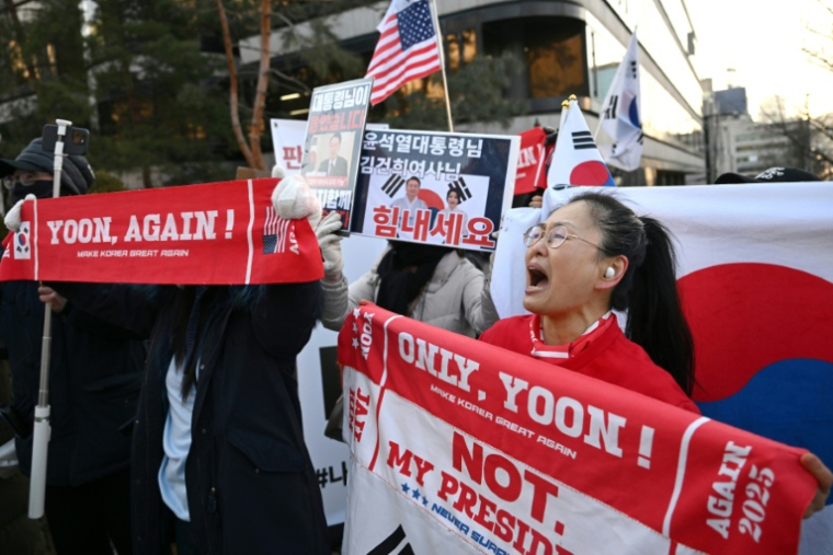 Des partisans de l'ancien président sud-coréen destitué, Yoon Suk Yeol, rassemblés devant le tribunal du district central de Séoul où doit se tenir son dernier procès pénal pour insurrection, le 13 janvier 2026 ( AFP / Jung Yeon-je )