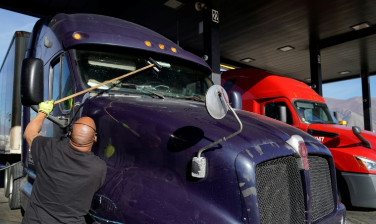 Un chauffeur routier nettoie son pare-brise à Springville, aux Etats-Unis, le 1er décembre 2021 ( AFP / GEORGE FREY )