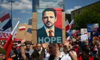 Un homme brandit un portrait du candidat pro-UE et maire de Varsovie Rafal Trzaskowski, le 25 mai 2025 à Varsovie ( AFP / Sergei GAPON )