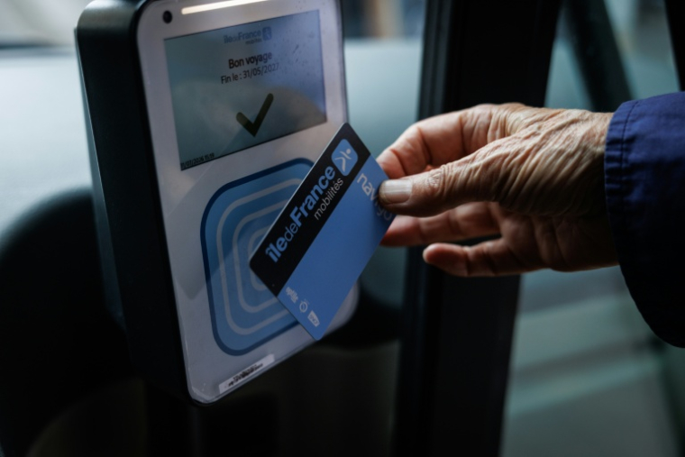 Un passager utilise son pass navigo, le forfait mensuel des transports publics en Ile-de-France, pour valider son trajet à bord du bus de la ligne 85 exploitée par la RATP à Paris, le 31 juillet 2026 ( AFP / Simon WOHLFAHRT )