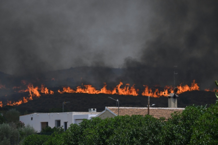 Une feu de forêt se rapproche d'une maison près de Bedar, dans le district de Los Gallardos, dans la province d'Almería, le 10 juillet 2026 en Espagne ( AFP / JOSE JORDAN )