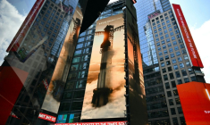 Images géantes de fusées SpaceX sur les murs d'immeubles de Times Square, à New York, non loin de celui du Nasdaq, le jour de l'entrée en Bourse, le 12 juin 2026.  ( AFP / ANGELA WEISS )