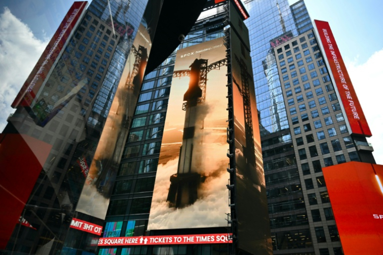Images géantes de fusées SpaceX sur les murs d'immeubles de Times Square, à New York, non loin de celui du Nasdaq, le jour de l'entrée en Bourse, le 12 juin 2026.  ( AFP / ANGELA WEISS )