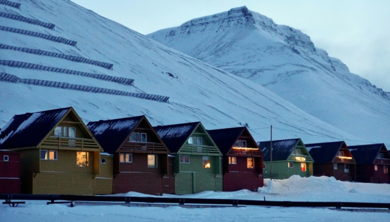 Des maisons traditionnelles colorées "Spisshus' au pied du mont Sukkertoppen au crépuscule à Longyearbyen, dans l'archipel norvégien du Svalbard, le 17 février 2026 ( AFP / Oriane Laromiguière )