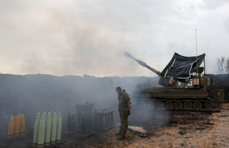 Un soldat israélien se tient près d’une unité d’artillerie mobile, près de la frontière avec le Liban