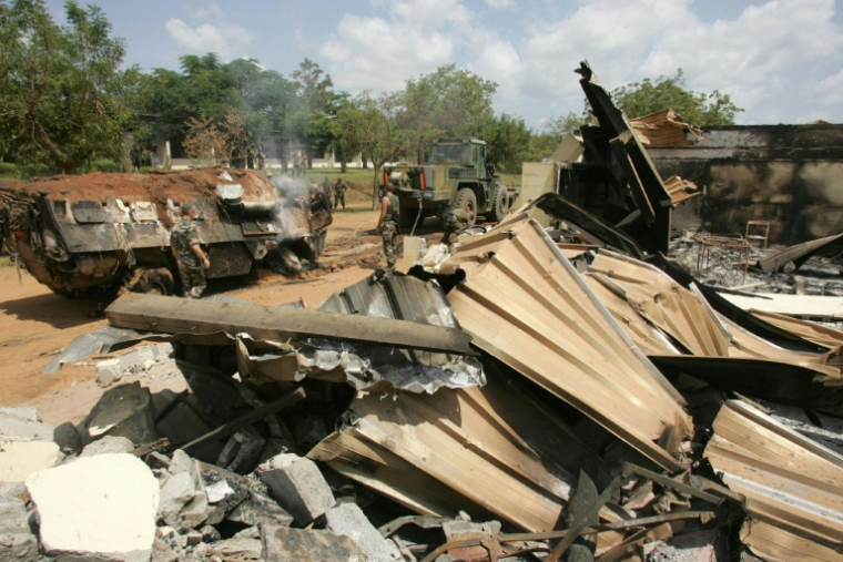 Des soldats français dégagent les décombres du lycée Descartes de Bouaké, le 10 novembre 2004, qui leur servait de base, après un bombardement le 4 novembre 2004, en Côte d'Ivoire ( AFP / PHILIPPE DESMAZES )