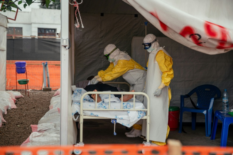 Des membres de Médecins Sans Frontières (MSF), en combinaison de protection, dans la zone d'isolement pour les patients atteints du virus Ebola au Centre de traitement Ebola (CTE) de Munigi, le 2 juin 2026 en RDC ( AFP / Jospin Mwisha )