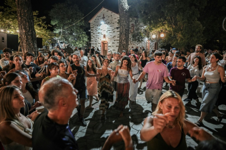 Locaux et vacanciers dansent un "panigiri", une tradition en Grèce, au village du Prophète Elie, sur l'île d'Ikaria, le 20 juillet 2025The "panigiri" are patron saint festivals that mark the summer in all the villages of the Greek islands and on the mainland, deeply rooted in Greek culture. Celebrations and dances often continue until dawn, attracting large crowds and many tourists. Each "panigiri" is associated with the feast day of a local patron saint, such as the Prophet Elijah on July 20 and Saint John on August 28. Its origins date back to 1821. ( AFP / Aris MESSINIS )
