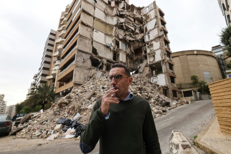 Wael Sabbagh, qui a perdu sa mère et son frère dans une frappe israélienne contre leur immeuble, se tient devant le bâtiment, dans le quartier de Tallet el-Khayat, à Beyrouth, le 18 mai 2026 ( AFP / Anwar AMRO )
