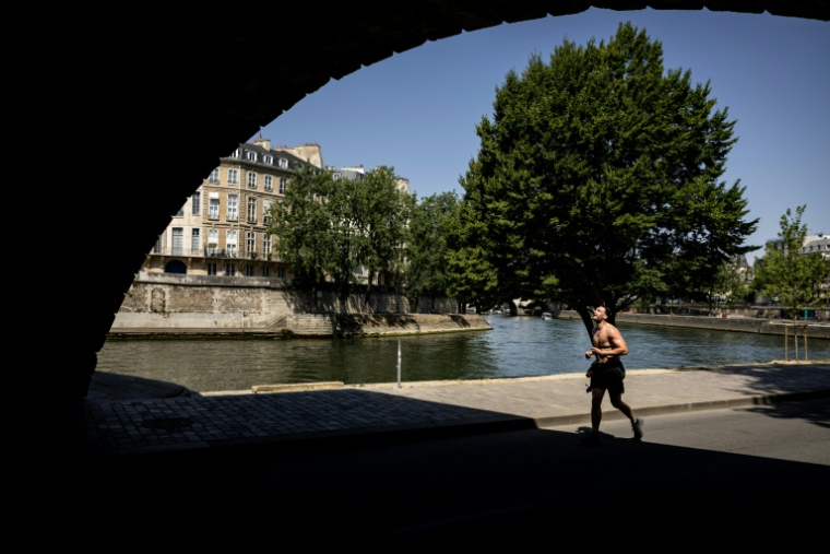 Un homme fait son footing sur les bords de Seine à Paris lors d'un épisode de canicule le 24 juin 2026 ( AFP / Simon WOHLFAHRT )