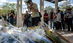 Des personnes se rassemblent le 29 novembre 2025 pour déposer des fleurs devant le complexe résidentiel de Wang Fuk Court à Hong Kong à la suite de l’incendie meurtrier survenu trois jours auparavant ( AFP / Philip FONG )