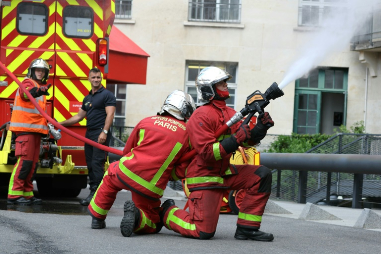 Un pompier de Paris actionne une nouvelle lance à incendie dite "diphasique" lors d'une présentation à la presse à la caserne Champerret à Paris, le 26 juin 2025 ( AFP / Thomas SAMSON )