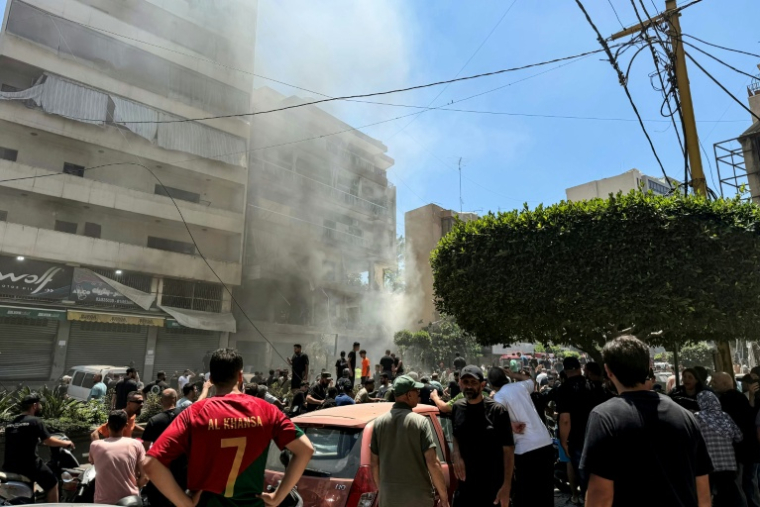Des habitants sur le site d'une frappe aérienne israélienne qui a ciblé un bâtiment dans la banlieue sud de Beyrouth, le 14 juin 2026 au Liban ( AFP / Ibrahim AMRO )