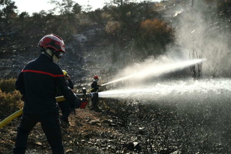 Les sapeurs-pompiers luttent pour combattre ce qu'il reste de l'incendie dans l'Aude et éviter qu'il ne reparte, à Albas, le 9 août 2025 ( AFP / Bertrand GUAY )