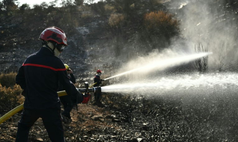 Les sapeurs-pompiers luttent pour combattre ce qu'il reste de l'incendie dans l'Aude et éviter qu'il ne reparte, à Albas, le 9 août 2025 ( AFP / Bertrand GUAY )