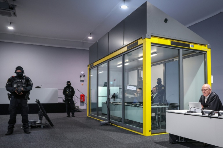 L'auteur présumé de l'attentat du marché de Noël à Magdebourg (est de l'Allemagne), le Saoudien islamophobe Taleb Jawad al-Abdulmohsen, brandit un ordinateur portable, dans un box vitré sécurisé, lors de son procès au tribunal, le 10 novembre 2025 ( AFP / Ronny HARTMANN )