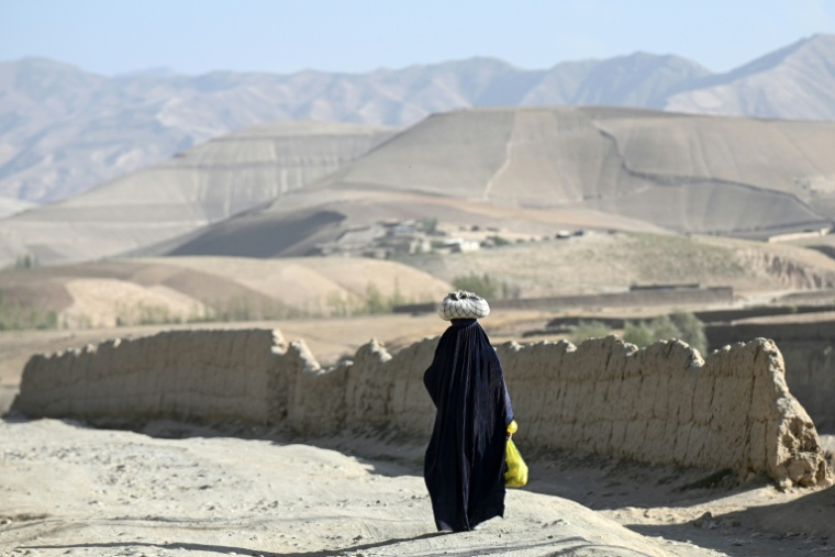 Une Afghane en burqa sur une route du district d'Argo, dans la province de Badakhshan, en Afghanistan, le 15 septembre 2026 ( AFP / Omer ABRAR )