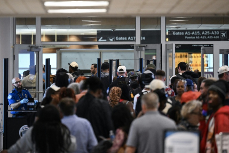 Des voyageurs patientent dans de longues files d'attente aux contrôles de sécurité de l'aéroport intercontinental George Bush de Houston, au Texas, le 23 mars 2026 ( AFP / RONALDO SCHEMIDT )