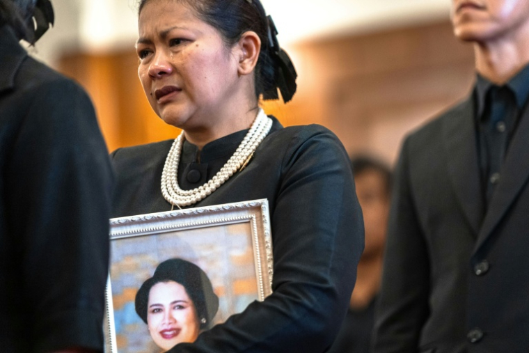 Une femme endeuillée pleure dans la queue pour rendre hommage à l'ancienne reine Sirikit de Thaïlande au Grand Palais de Bangkok, le 26 octobre 2025 ( AFP / Chanakarn Laosarakham )