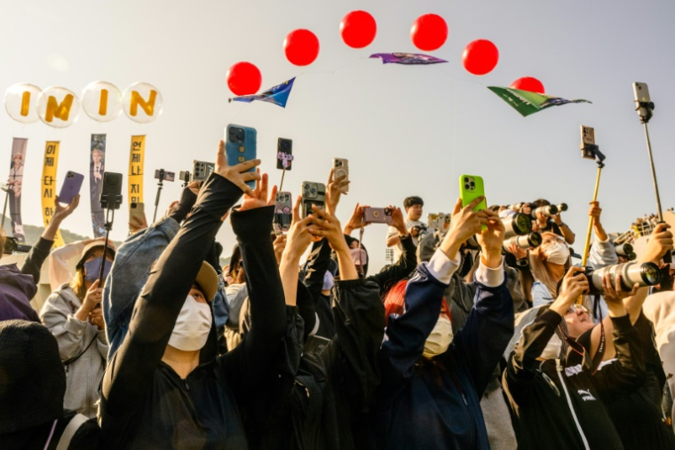 Des fans photographient Jungkook et Jimin, du groupe de K-pop BTS, à leur arrivée à Yeoncheon, le 11 juin 2025 en Corée du Sud, peu après leur libération de 18 mois de service militaire ( AFP / ANTHONY WALLACE )