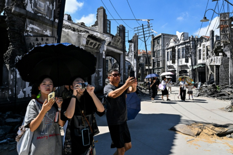 Des touristes chinois visitent le lieu de tournage du film "Dead to Rights" à Shanghai, le 27 août 2025 en Chine ( AFP / Hector RETAMAL )