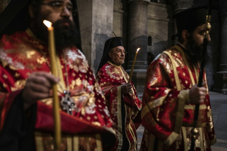 Des prêtres orthodoxes grecs arrivent à l'église du Saint-Sépulcre avant la cérémonie du lavement des pieds, dans la vieille ville de Jérusalem, le 9 avril 2026 ( AFP / JOHN WESSELS )