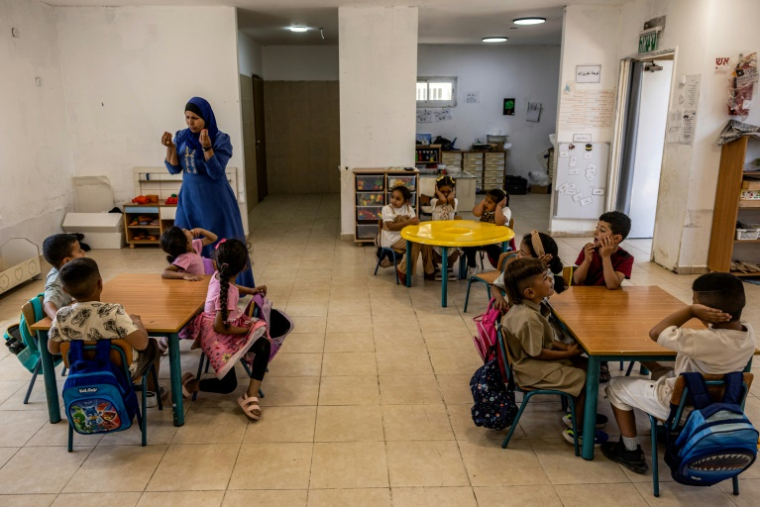 Une enseignant dans la salle de classe d'un jardin d'enfants alimenté par des panneaux solaires photovoltaïques dans le village bédouin d'Umm Batin près de Beersheva, dans le désert du Néguev, au sud d'Israël, le 11 juin 2025 ( AFP / Menahem Kahana )