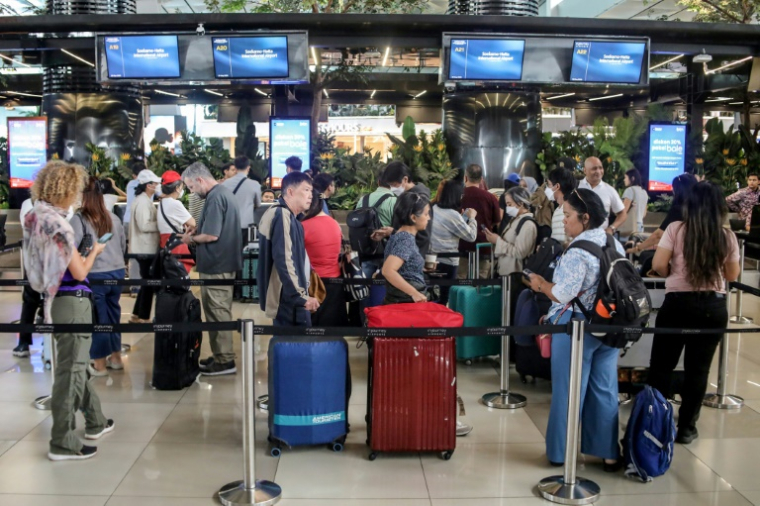 Des voyageurs bloqués à l'aéroport Soekarno-Hatta de Tangerang font la queue pour demander le remboursement de leurs billets après l'annulation de vols réguliers due à l'éruption du volcan Anak Krakatoa, le 6 septembre 2026 en Indonésie ( AFP / ABIMANYU )