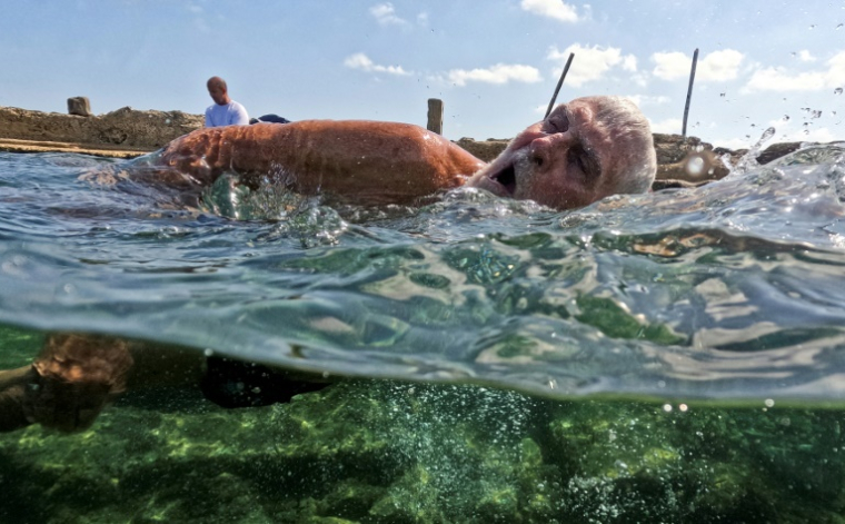 Un membre du club de natation "Jeunesse accumulée" nage dans une piscine d'eau de mer à La Havane, le 17 mai 2025 ( AFP / YAMIL LAGE )