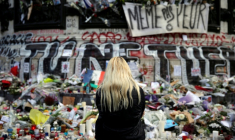 Une femme se recueille devant un mémorial improvisé composé de fleurs, de bougies et de messages, place de la République à Paris, le 17 novembre 2015, en hommage aux victimes des attentats du 13 novembre 2015 ( AFP / Kenzo TRIBOUILLARD )