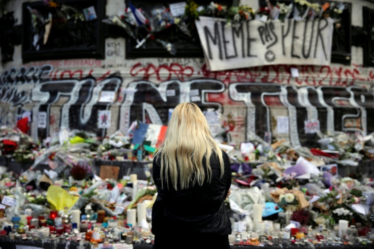Une femme se recueille devant un mémorial improvisé composé de fleurs, de bougies et de messages, place de la République à Paris, le 17 novembre 2015, en hommage aux victimes des attentats du 13 novembre 2015 ( AFP / Kenzo TRIBOUILLARD )