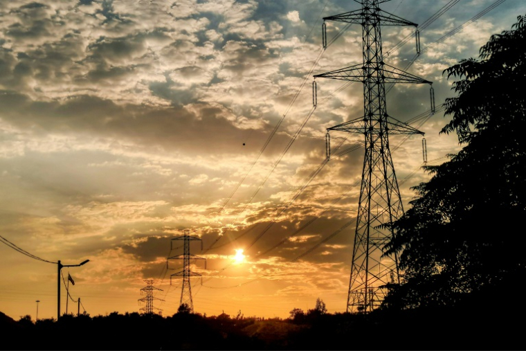 Des pylônes électriques à haute tension au coucher du soleil, dans l'ouest de Téhéran, le 2 août 2022 ( AFP / ATTA KENARE )