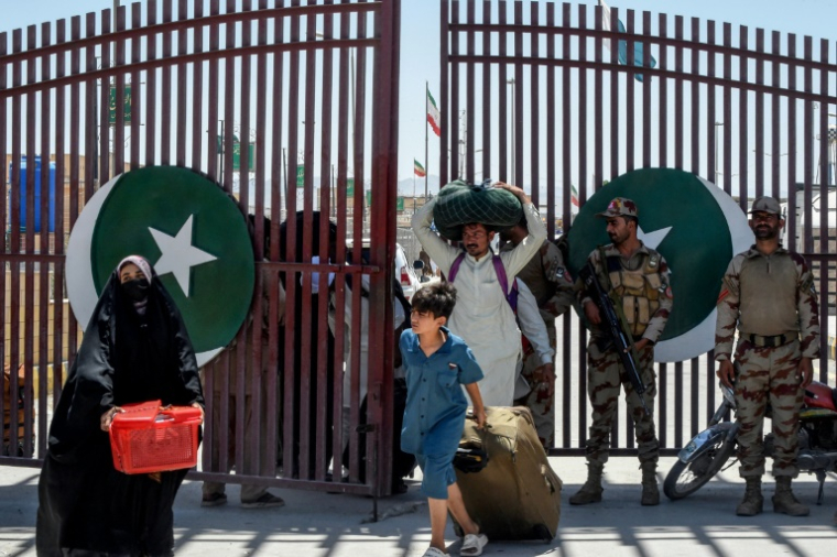 Des pèlerins pakistanais fuient l'Iran en traversant à pied la frontière fermée, le 18 juin 2025 à Taftan (Baloutchistan) ( AFP / Banaras KHAN )
