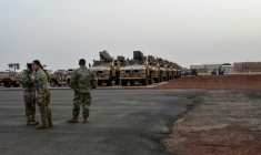 Des soldats américains devant des véhicules militaires qu'ils s'apprêtent à embarquer à bord d'un avion cargo à Niamey, le 7 juin 2024, lors de la cérémonie marquant le premier départ de troupes américaines du Niger ( AFP / BOUREIMA HAMA )