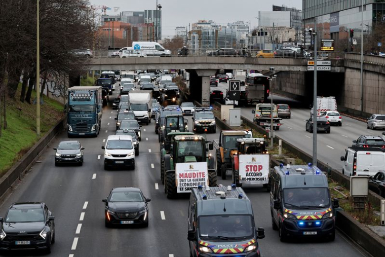 Des agriculteurs de la Confédération Paysanne conduisent lentement leurs tracteurs sur le périphérique parisien