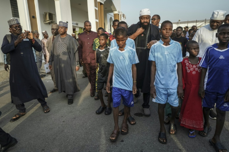 Des écoliers arrivent au siège du gouverneur local à Minna le 8 décembre 2025. Une centaine d'écoliers qui avaient été enlevés le mois dernier par des hommes armés dans une école catholique sont arrivés au siège du gouvernement à Minna, la capitale de l'État du Niger, dans le centre-nord du Nigeria, comme l'ont observé lundi des journalistes de l'AFP. Cependant, le sort des 165 autres personnes enlevées avec eux reste inconnu. Les élèves, âgés pour la plupart de 10 à 17 ans, sont arrivés dans cinq bus blancs escortés par une dizaine de véhicules militaires et blindés et ont été reçus par le gouverneur de l'État du Niger, Mohammed Umaru Bago. ( AFP / Light Oriye Tamunotonye )