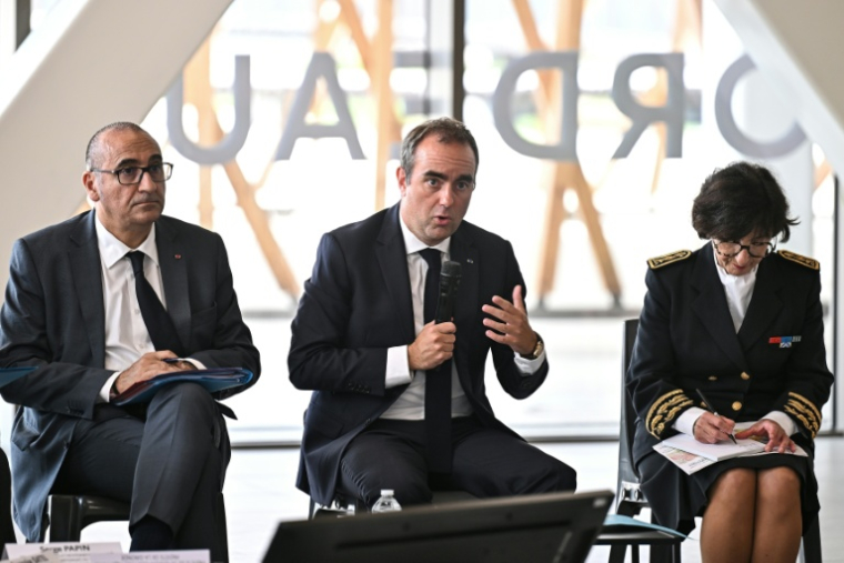 Le Premier ministre Sébastien Lecornu (c) aux côtés du ministre de l'Intérieur Laurent Nuñez (g) et de responsables lors d'une réunion à Mérignac, près de Bordeaux, le 17 août 2026 en Gironde, après un incendie de forêt ( POOL / Christophe ARCHAMBAULT )
