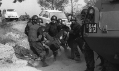 Des gendarmes évacuent un collègue blessé lors de leur intervention pour libérer six hommes pris en otage par des indépendantistes corses masqués et armés dans la cave à vin « Sovicor » à Aléria, en Corse, le 22 août 1975 ( AFP / STF )