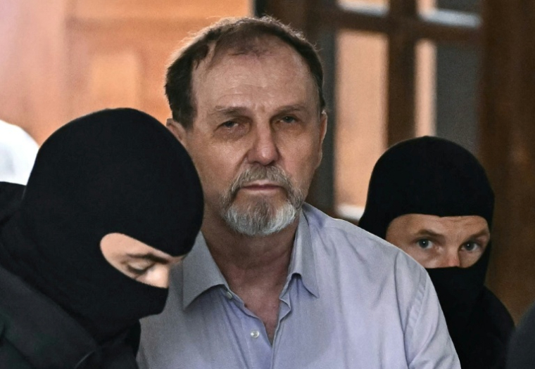 La police escorte Juraj Cintula jusqu'à la salle d'audience de Banska Bystrica, en Slovaquie, le 8 juillet 2025, pour le début de son procès où il est accusé d'avoir tiré sur le Premier ministre slovaque Robert Fico ( AFP / Joe Klamar )