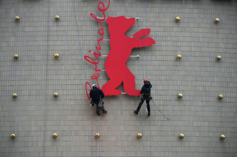 Des escaladeurs industriels fixent un Ours de la Berlinale sur la façade du cinéma Zoo Palast à Berlin, le 10 février 2026 ( AFP / RALF HIRSCHBERGER )