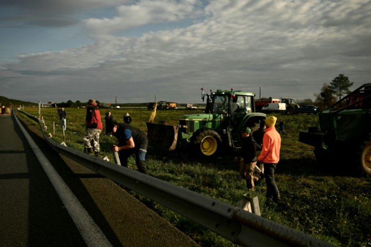 Des agriculteurs français démontent des barrières métalliques le long de l'autoroute A63 bloquée au niveau de l'échangeur de Cestas, en Gironde, le 16 décembre 2020 ( AFP / Philippe LOPEZ )