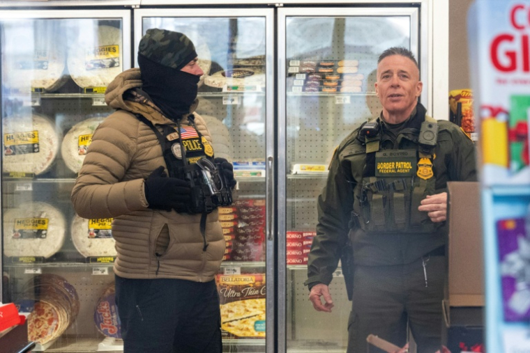 Le haut responsable de la police aux frontières américaine, Gregory Bovino, parle avec un agent à l'intérieur d'une station-service de Minneapolis (Minnesota), le 21 janvier 2026 ( AFP / ROBERTO SCHMIDT )