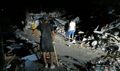 Des secouristes éclairent la zone à l'aide des phares d'un pick-up tout en recherchant d'éventuelles victimes dans un bâtiment effondré à la suite de deux séismes, à Caraballeda, dans l'Etat de La Guaira, au Venezuela, le 27 juin 2026 ( AFP / Mauricio VALENZUELA )