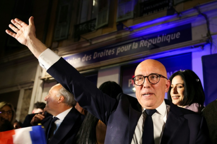 Éric Ciotti, président du groupe parlementaire UDR et candidat à la mairie de Nice pour l'Union de la droite et le Rassemblement national (RN), salue des partisans à son arrivée au QG de campagne à l'issue du 2e tour des municipales à Nice, le 22 mars 2026 dans les Alpes-Maritimes ( AFP / Valery HACHE )