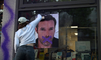 Une militante féministe colle une affiche dénonçant la publication d'un livre de Nicolas Bedos, condamné en octobre pour agressions sexuelles, le 23 mai 2025 à Paris ( AFP / Leo VIGNAL )