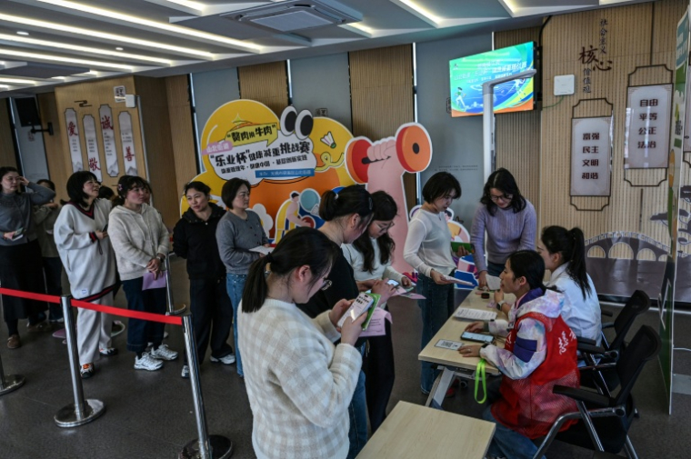 Des participantes au programme minceur "Perdez du gras, gagnez du boeuf" attendent pour se faire peser dans un centre communautaire de Wuxi, dans la province du Jiangsu, le 23 mars 2026 dans l'est de la Chine ( AFP / Jade GAO )