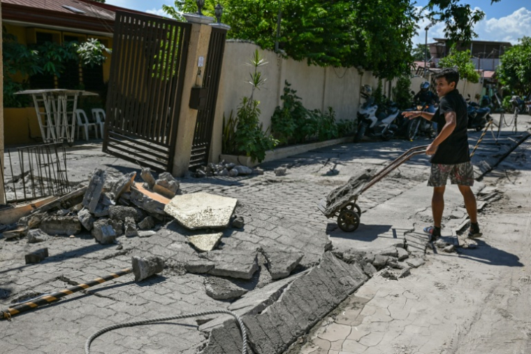 Un homme nettoie les débris d'une maison endommagée par le séisme à General Santos aux Philippines le 9 juin 2026 ( AFP / Jam STA ROSA )