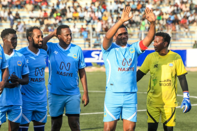L'ancienne star du football camerounais Samuel Eto'o, deuxième à gauche, salue le public avant un match de gala à Mogadiscio, capitale de la Somalie, le 27 mai 2025 ( AFP / Hassan Ali Elmi )