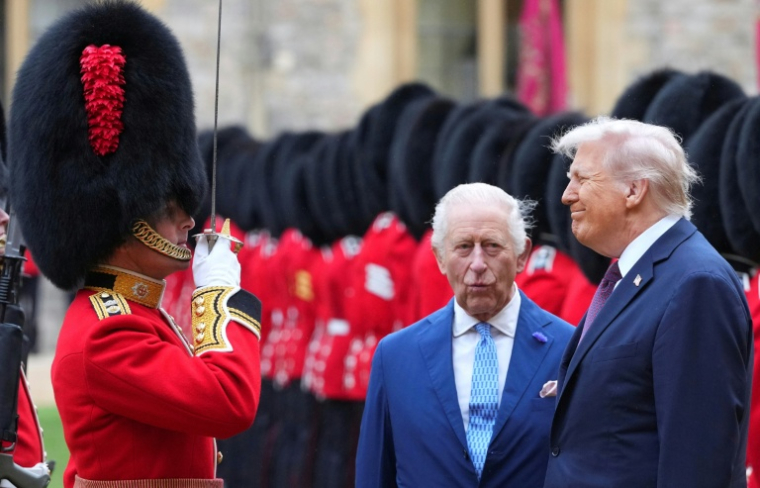 Le président américain Donald Trump (d) et le roi Charles III passent en revue la Garde d'honneur au château de Windsor, lors de la deuxième visite d'Etat du président américain, le 17 septembre 2025 à Windsor ( POOL / Kirsty Wigglesworth )